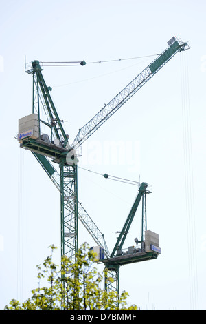 Zwei Kräne auf der Baustelle, wo neue Häuser errichtet werden. Stockfoto