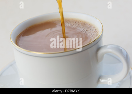 Gießen Tee in eine Teetasse Weißware. England, UK, Großbritannien Stockfoto