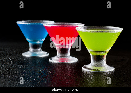 hellen Mini Martinis serviert auf einem nassen dunklen bar oben für einen dramatischen Effekt Stockfoto