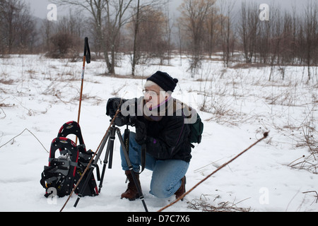 Eine Frau-Fotograf ist auf die Jagd auf Schneeschuhen an einem winterlichen Tag in den Berkshires, Massachusetts. Stockfoto