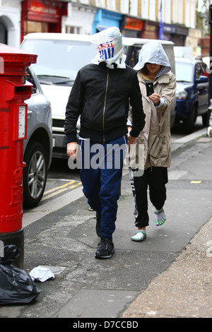 Matt Bellamy und Kate Hudson zu Fuß im Norden Londons. Bellamy bedeckt den Kopf mit einer Tesco-Tasche, mit einem einzigen Blick Stockfoto