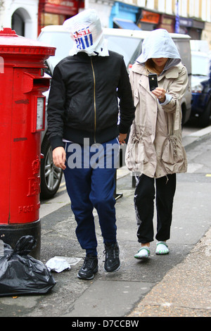 Matt Bellamy und Kate Hudson zu Fuß im Norden Londons. Bellamy bedeckt den Kopf mit einer Tesco-Tasche, mit einem einzigen Blick Stockfoto