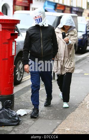 Matt Bellamy und Kate Hudson zu Fuß im Norden Londons. Bellamy bedeckt den Kopf mit einer Tesco-Tasche, mit einem einzigen Blick Stockfoto