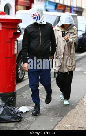 Matt Bellamy und Kate Hudson zu Fuß im Norden Londons. Bellamy bedeckt den Kopf mit einer Tesco-Tasche, mit einem einzigen Blick Stockfoto