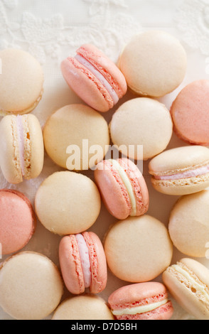 Ein Haufen französische Mandel Macarons auf weißem Holz und Spitze, Teil einer Serie. Stockfoto