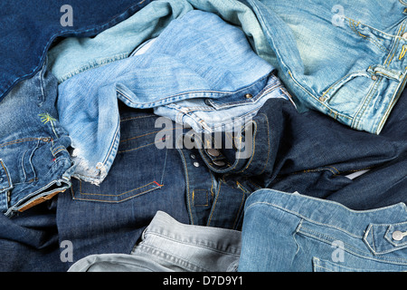 Verschiedene Paare von Jeanshosen verstreut im Chaos. Stockfoto