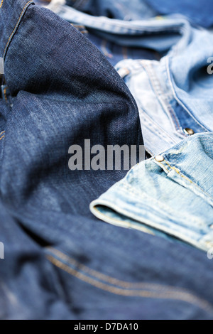 Verschiedene Paare von Jeanshosen verstreut im Chaos. Stockfoto