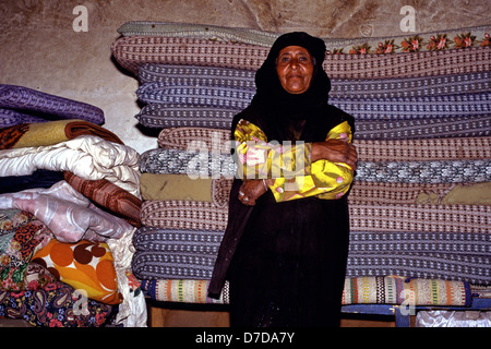 Eine ältere Frau aus der Beduinen Bedul Stamm einer Der Huwaitat Stämmen, die historisch in Petra gelebt haben, die traditionelle Kleidung in einer Höhle Residence in Felsen gehauene von Wadi Musa in der Nähe von Petra Jordanien Stockfoto