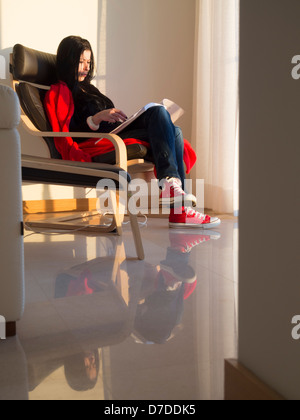 Junge Frau, ein Buch zu Hause Stockfoto