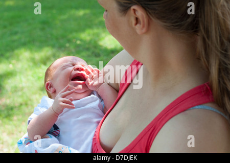 Schreiendes neugeborenes Baby und Mutter von hinten im freien Stockfoto