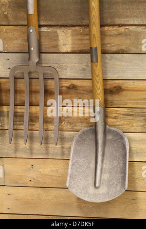 Garten-Utensilien an Holzwand hängen Stockfoto