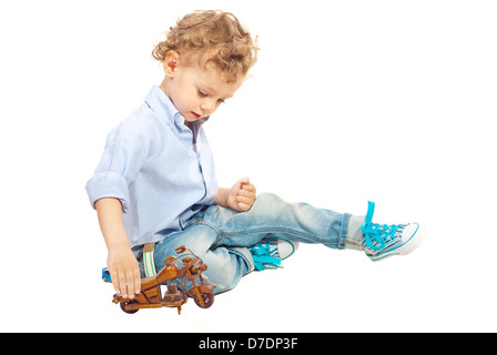 Kind Junge spielt mit hölzernen Bike nach Hause isoliert auf weißem Hintergrund Stockfoto