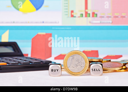 Würfel Würfel mit den Worten zu verkaufen, kaufen ein-Euro-Münze, Taschenrechner und finanzielle Diagramme als Hintergrund. Selektiven Fokus Stockfoto
