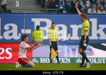 Schiedsrichter Jochen Drees zeigt Wolfsburgs Heung Min Son (L) die gelbe Karte während der Fußball-Bundesligaspiel zwischen dem Hamburger SV und VfL Wolfsburg in Imtech Arena in Hamburg, Deutschland, 5. Mai 2013. Foto: MARCUS BRANDT (Achtung: EMBARGO Bedingungen! Die DFL ermöglicht die weitere Nutzung der nur bis zu 15 Bilder (keine Sequntial Bilder oder Video-ähnliche Reihe der Bilder erlaubt) über das Internet und Online-Medien während des Spiels (einschließlich Halbzeit), im Stadion oder vor dem Start des Spiels entnommen. Die DFL erlaubt die uneingeschränkte Übertragung von digitalisierten Aufnahmen d Stockfoto