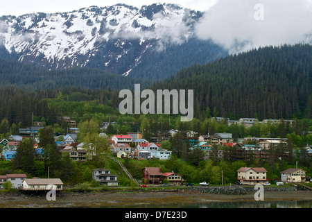 Kleines Dorf in Alaska mit Schnee bedeckt, Berge und Wolken Stockfoto