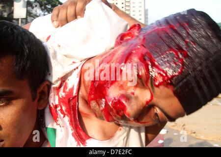 Dhaka, Bangladesch. 5. Mai 2013. Zivile Personen tragen einen verletzten islamistischen Demonstranten bei Zusammenstößen mit der Polizei in Dhaka am 5. Mai 2013.Thousands der Islamisten Dhaka am 05 Mai zum Stillstand gebracht, wie sie eine Anti-Blasphemie-Gesetz gefordert, die die Todesstrafe steht, und Beamte sagten, dass ein Arbeiter bei Zusammenstößen zwischen Demonstranten und der Polizei getötet wurde. Unterstützer der radikalen Hefazat-e-Islam-Gruppe durchgeführt Stöcke und blockiert wichtige Einstiegspunkte in die Stadt Stockfoto