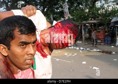 Dhaka, Bangladesch. 5. Mai 2013. Zivile Personen tragen einen verletzten islamistischen Demonstranten bei Zusammenstößen mit der Polizei in Dhaka am 5. Mai 2013.Thousands der Islamisten Dhaka am 05 Mai zum Stillstand gebracht, wie sie eine Anti-Blasphemie-Gesetz gefordert, die die Todesstrafe steht, und Beamte sagten, dass ein Arbeiter bei Zusammenstößen zwischen Demonstranten und der Polizei getötet wurde. Unterstützer der radikalen Hefazat-e-Islam-Gruppe durchgeführt Stöcke und blockiert wichtige Einstiegspunkte in die Stadt Stockfoto