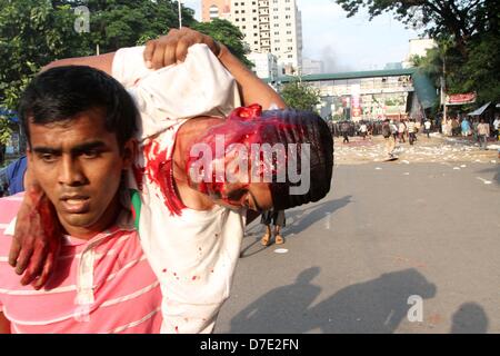 Dhaka, Bangladesch. 5. Mai 2013. Zivile Personen tragen einen verletzten islamistischen Demonstranten bei Zusammenstößen mit der Polizei in Dhaka am 5. Mai 2013.Thousands der Islamisten Dhaka am 05 Mai zum Stillstand gebracht, wie sie eine Anti-Blasphemie-Gesetz gefordert, die die Todesstrafe steht, und Beamte sagten, dass ein Arbeiter bei Zusammenstößen zwischen Demonstranten und der Polizei getötet wurde. Unterstützer der radikalen Hefazat-e-Islam-Gruppe durchgeführt Stöcke und blockiert wichtige Einstiegspunkte in die Stadt Stockfoto