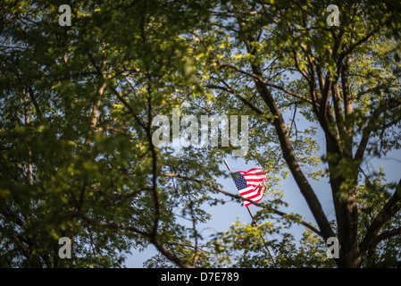 Die Flagge zeigt durch die Bäume auf Iwo Jima Memorial (formal das Marine Corps War Memorial) in Arlington, Virginia, neben Arlington Staatsangehörig-Kirchhof. Das Denkmal wurde von Felix de Wledon entworfen und basiert auf einer legendären Associated Press Foto bezeichnet die Erhöhung der Flagge auf Iwo Jima von Joe Rosenthal. Es wurde 1954 eingeweiht. Stockfoto