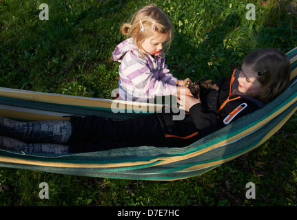 Zwei Kinder blond Mädchen ausruhen in der Hängematte-Sommerzeit Stockfoto