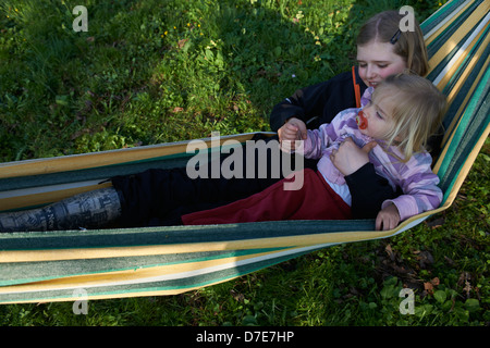 Zwei Kinder blond Mädchen ausruhen in der Hängematte-Sommerzeit Stockfoto