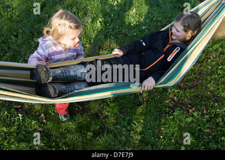 Zwei Kinder blond Mädchen ausruhen in der Hängematte-Sommerzeit Stockfoto