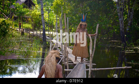 ein Mitglied des Stammes Yagua indigenen überquert eine Brücke in den Amazonas-Regenwald, Peru Stockfoto