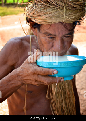 Ein Amazonas Mann vom Stamm Yagua trinkt traditionelle Chicha, ein Getränk aus gekaut und fermentierten Maniok/Maniokwurzel. Stockfoto