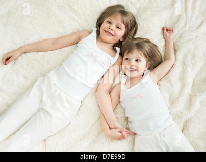 glückliche kleine Schwestern liegen wieder Draufsicht Stockfoto