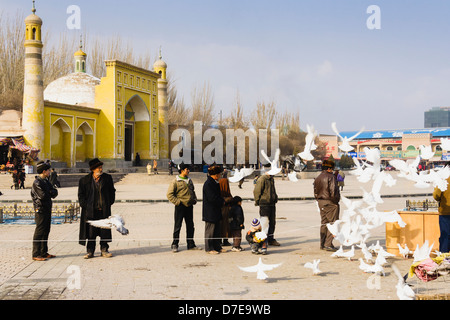 Uyghur Männer und Tauben von der ID-Kah Moschee in Kashgar, Xinjiang, China Stockfoto