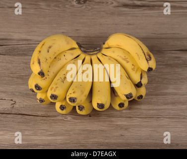 Gelbe Bananen auf hölzernen Hintergrund Stockfoto