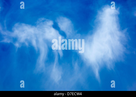 Weiße Wolkenfetzen vor tiefblauem Himmel Stockfoto