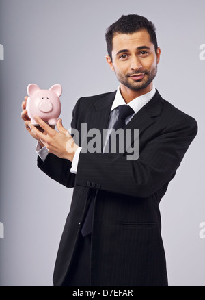 Fröhlich Executive zeigt Sie ein Sparschwein Stockfoto