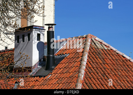 Schornstein auf einem Hintergrund des Himmels und des Daches Stockfoto