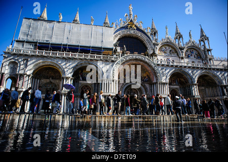 Touristen vor dem Markusdom während der Saison "Acqua Alta" in Venedig, Italien. Stockfoto