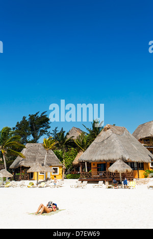 Cabana-Stil Unterkunft am Strand mit single-Frau Sonne bräunen und lesen Stockfoto