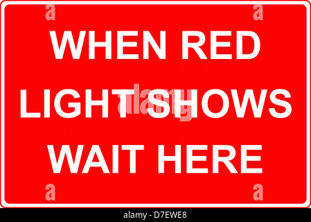 Wenn die rote Verkehrsampel auf „Warten Sie hier“ zeigt, ist das Straßenschild zu sehen Stockfoto