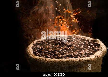 Sack voller noch warm, frisch gerösteten Kaffeebohnen mit fallenden Kaffeebohnen. Stockfoto