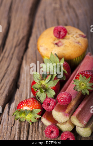 Einige frische und köstliche Früchte Zutaten für Muffins auf einem alten Holzbrett Stockfoto