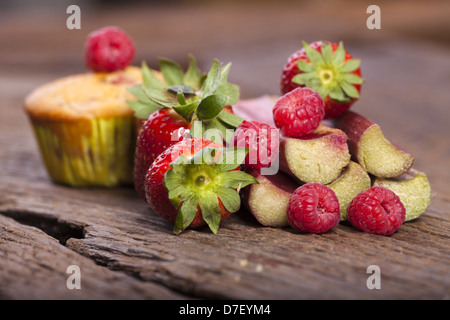 Einige frische und köstliche Früchte Zutaten für Muffins auf einem alten Holzbrett Stockfoto