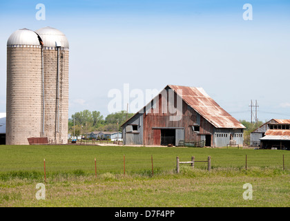 Eine alte hölzerne Scheune und zwei Silos auf dem Bauernhof im ländlichen Oklahoma, USA. Stockfoto