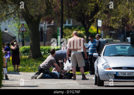 London, UK. 7. Mai 2013 der Öffentlichkeit begreifen eines zwei Straßenräuber, die Schmuck von einem Mann, der sein Kind im Kinderwagen schieben, auf Holz End Lane, Northolt entrissen.  Polizei kam dann und führte den Mann Weg. Bildnachweis: Martyn Wheatley/Alamy Live-Nachrichten Stockfoto