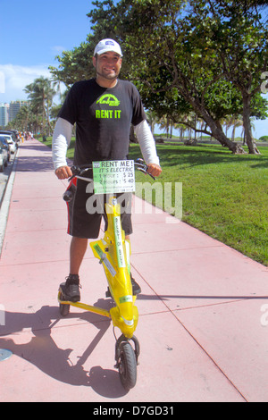 Miami Beach Florida, Ocean Drive, Lummus Park, Tribred von Trikke, Elektrofahrzeug, gemietet, Verleih, hispanischer Mann Männer männliche Erwachsene Erwachsene, Reiten, Angebot, stündlich ra Stockfoto