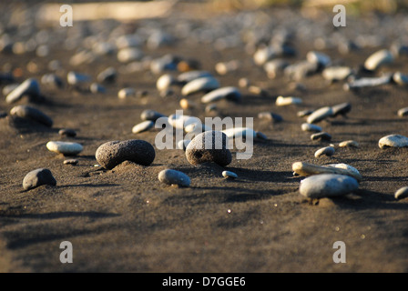 Der schwarze Sand, Asche und Steinen an den Hängen des Vulkans auf der Insel Kunaschir. Süd-Kurilen, Russland Stockfoto