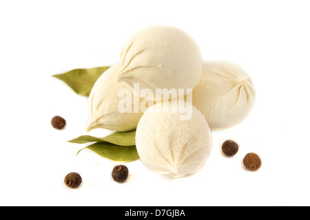 Ungekocht gefrorene Knödel (russische traditionelle Küche - Pelmeni) mit Pfeffer und Lorbeerblatt isoliert auf weißem Hintergrund hautnah. Stockfoto