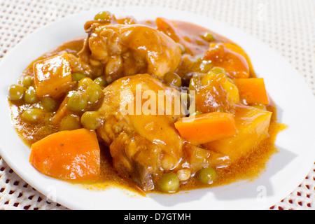 Hühnereintopf mit Kartoffeln, Möhren, grüne Erbsen in Tomatensauce. Stockfoto