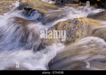 seidige Wasser fließt über die Felsen in einen kleinen Bach Stockfoto