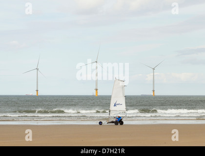 Land Segeln auf Redcar Strand mit Offshore-Windenergieanlagen im Hintergrund. Redcar, Cleveland, Nord-Ost-England, UK Stockfoto