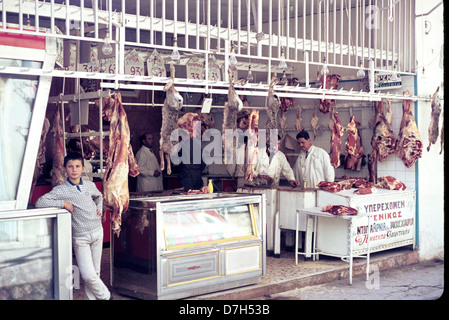 Besitzer-Sohn steht vor Fleischmarkt auch Kaninchen als Kunden Gespräche Metzger verkaufen. Stockfoto