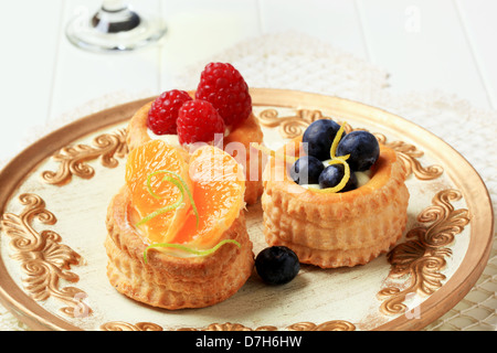 Pudding gefüllten Blätterteig Fällen mit frischen Früchten garniert Stockfoto